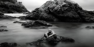A rocky coast standing exposed to mist and weather over the water.