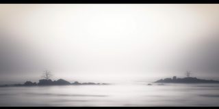 A faint, distant structure on the water, half-lost in mist.