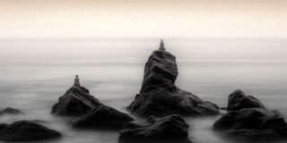 Stacked stones standing in the fog like cairns left behind.